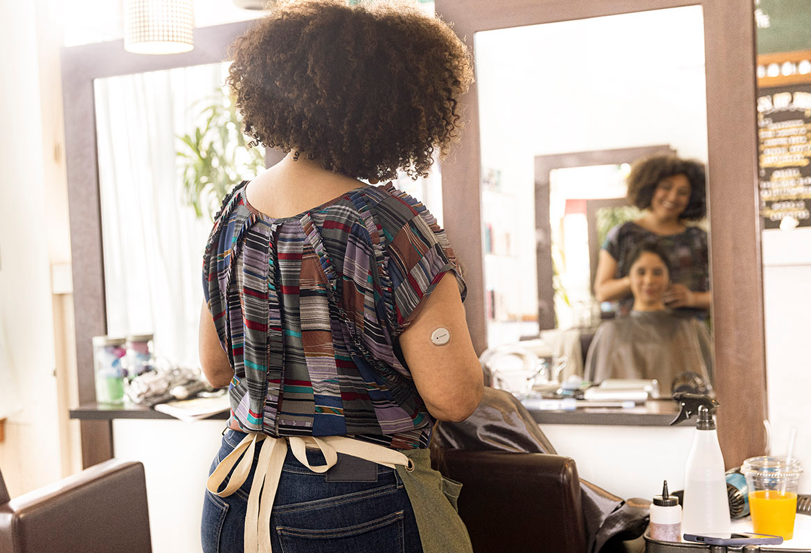 Hair stylist wearing the Dexcom G7 while working.